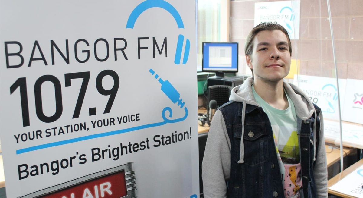 Scottie Watters beside a Bangor FM sign